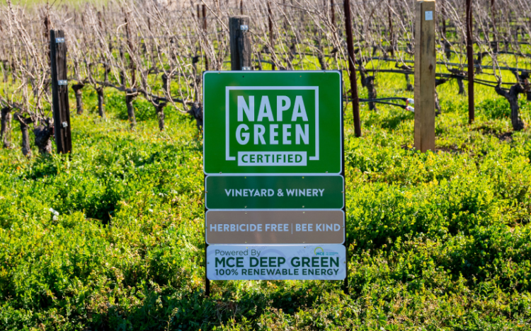 Napa Green certified sign featuring sub-signs "vineyards & winery" "herbicide free | bee kind" "MCE Deep Green 100% Renewable Energy"